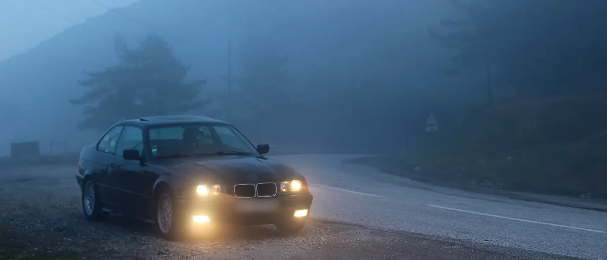 BMW coupe on a misty mountain road